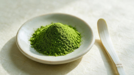 A mound of fine jade-green matcha powder with a bamboo scoop