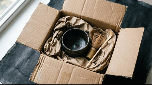 An opened gift box with Japanese tea tools packed inside