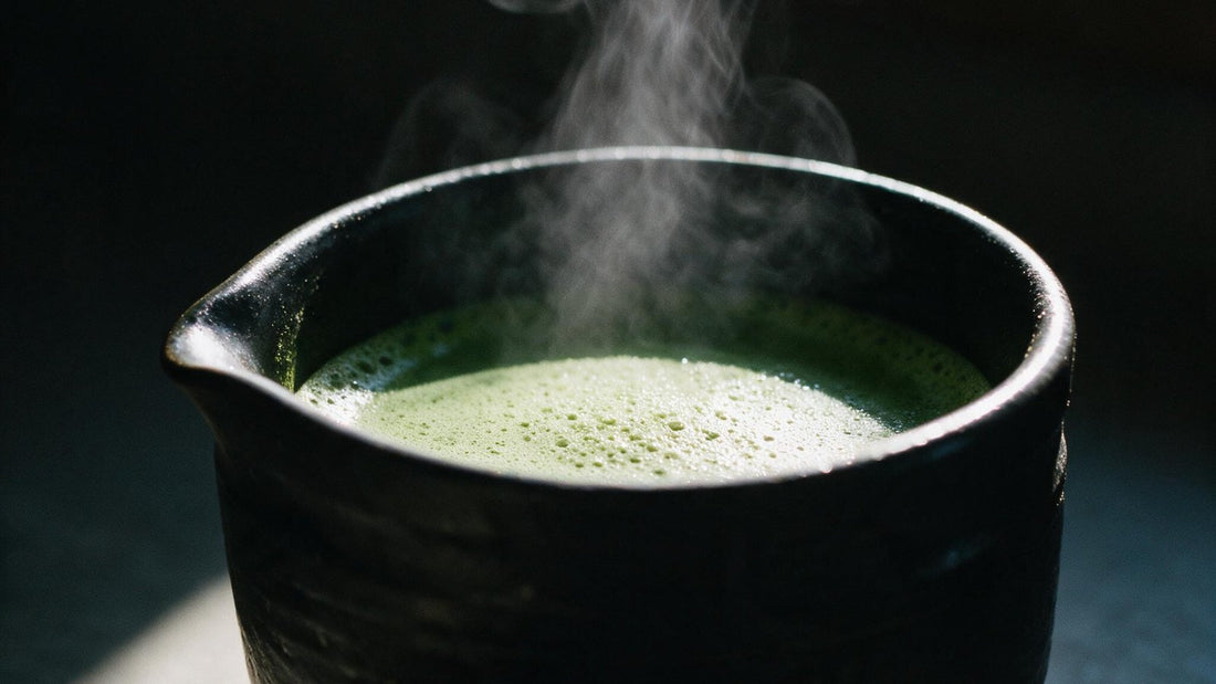 Steam rising from a dark tea bowl in a quiet room, lit from one side