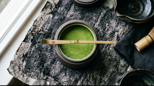 An opened tin of bright green matcha powder, its surface still smooth