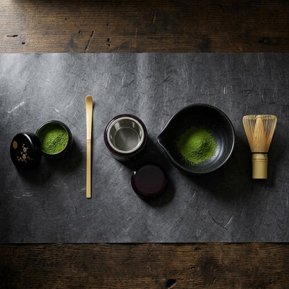 The five pieces laid out in the order you use them: the maki-e caddy open with matcha, the bamboo scoop, the earlier brown sifter with its mesh, the spouted black bowl with sifted matcha, and the Takayama whisk