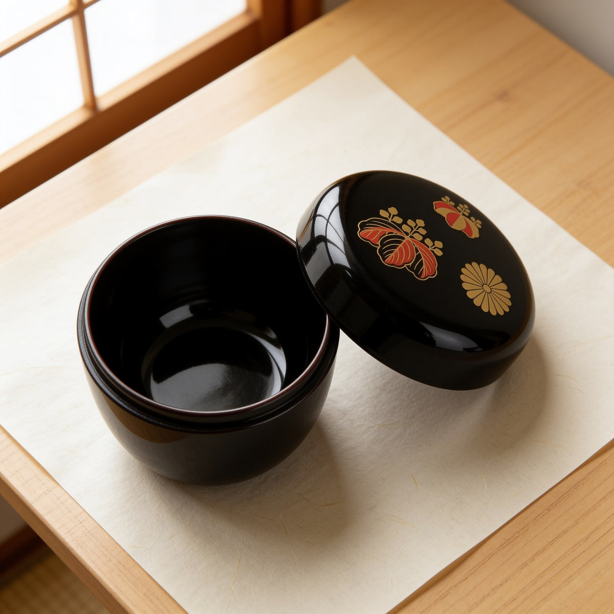 The natsume opened, its plain black interior empty, the decorated lid set beside it