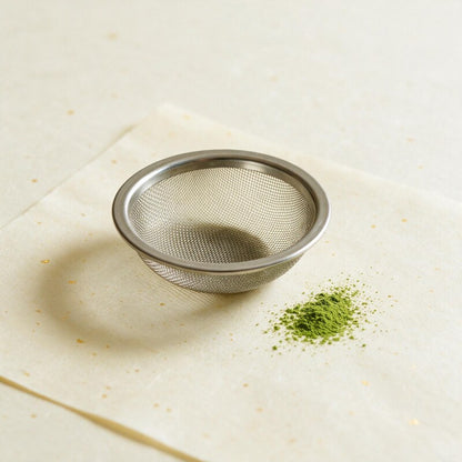 Small round stainless matcha sifter on washi with matcha powder