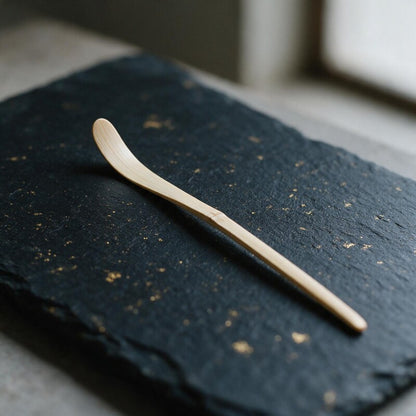 Takayama white-bamboo tea scoop (chashaku) on dark slate