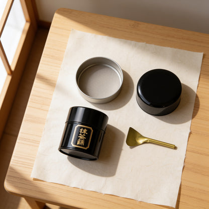 The sifter's parts laid out from above: tin, lid, shallow mesh tray and brass spatula