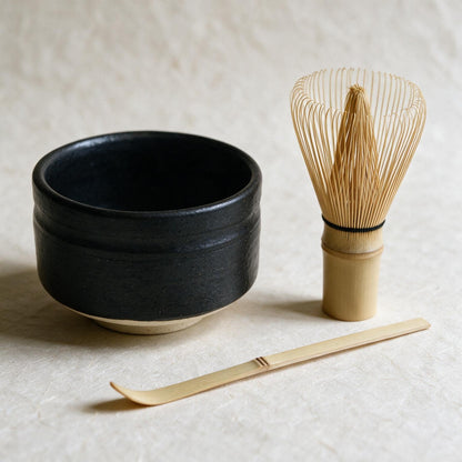 The starter set on washi: the low, wide Mino-yaki bowl, a Takayama chasen and a flat bamboo chashaku, at their true sizes